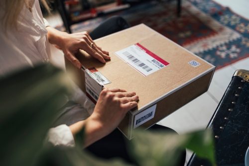 Online shopping- horizontal close up shot of female hands opening a package