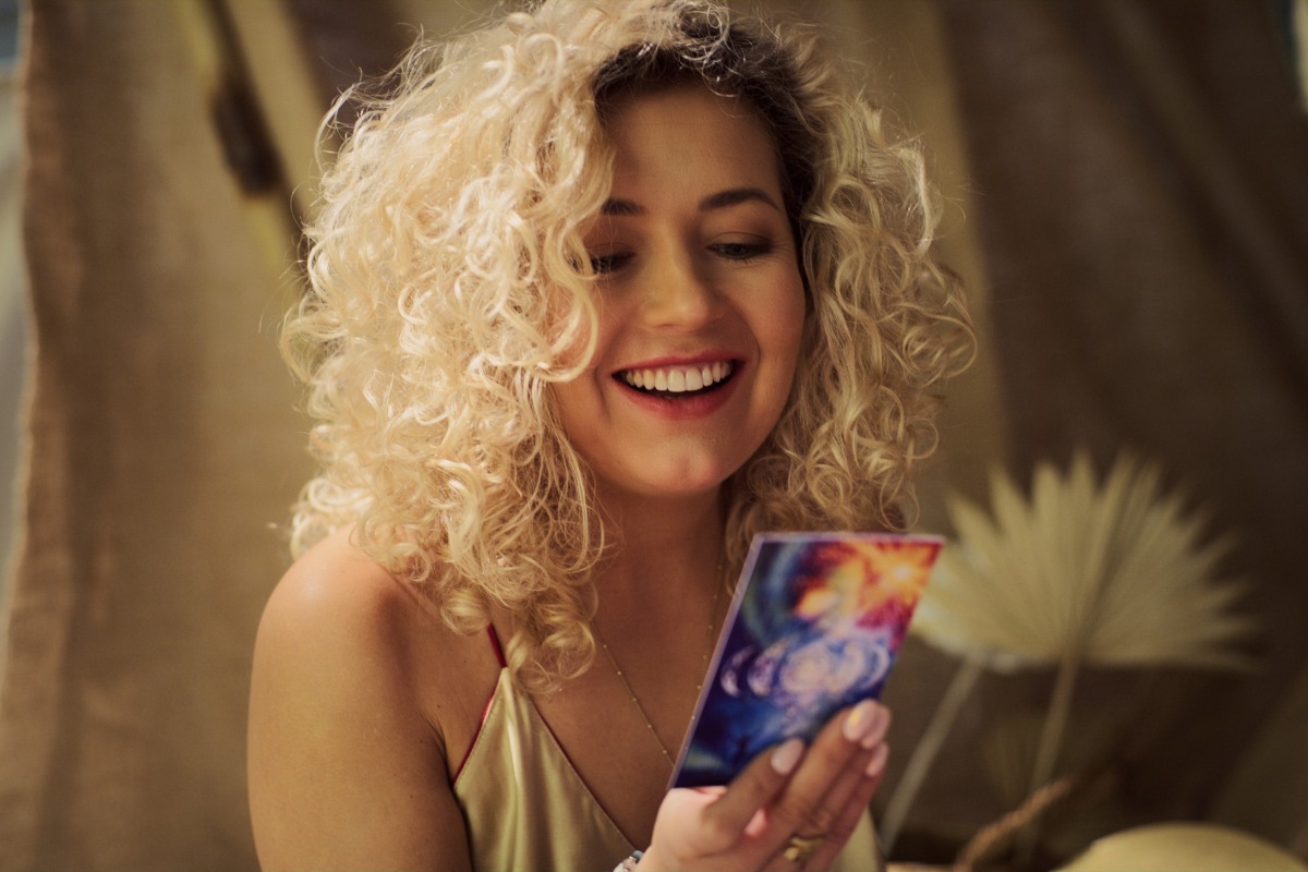 beautiful young blonde woman reading tarot