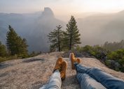 two people looking out over the rocks in a national park with their feet out