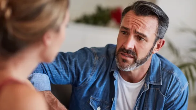 man looking concerned while talking to the woman across from him