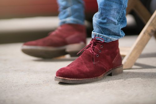 Close up of a man's feet in red suede desert boots