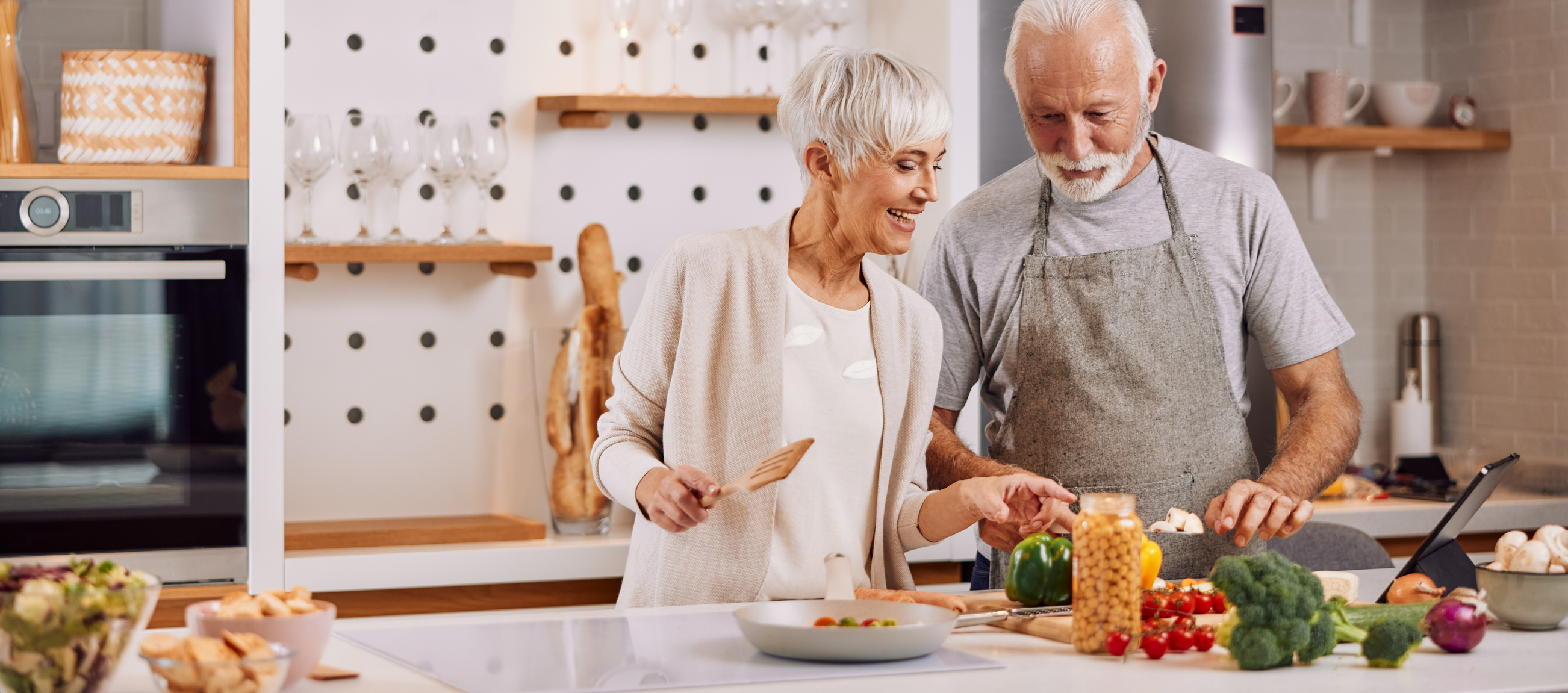 Senior couple chopping food in kitchen