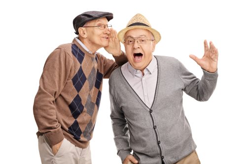 an old man whispering a short joke to his friend