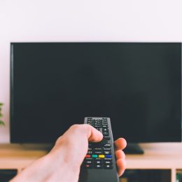 person using remote on tv