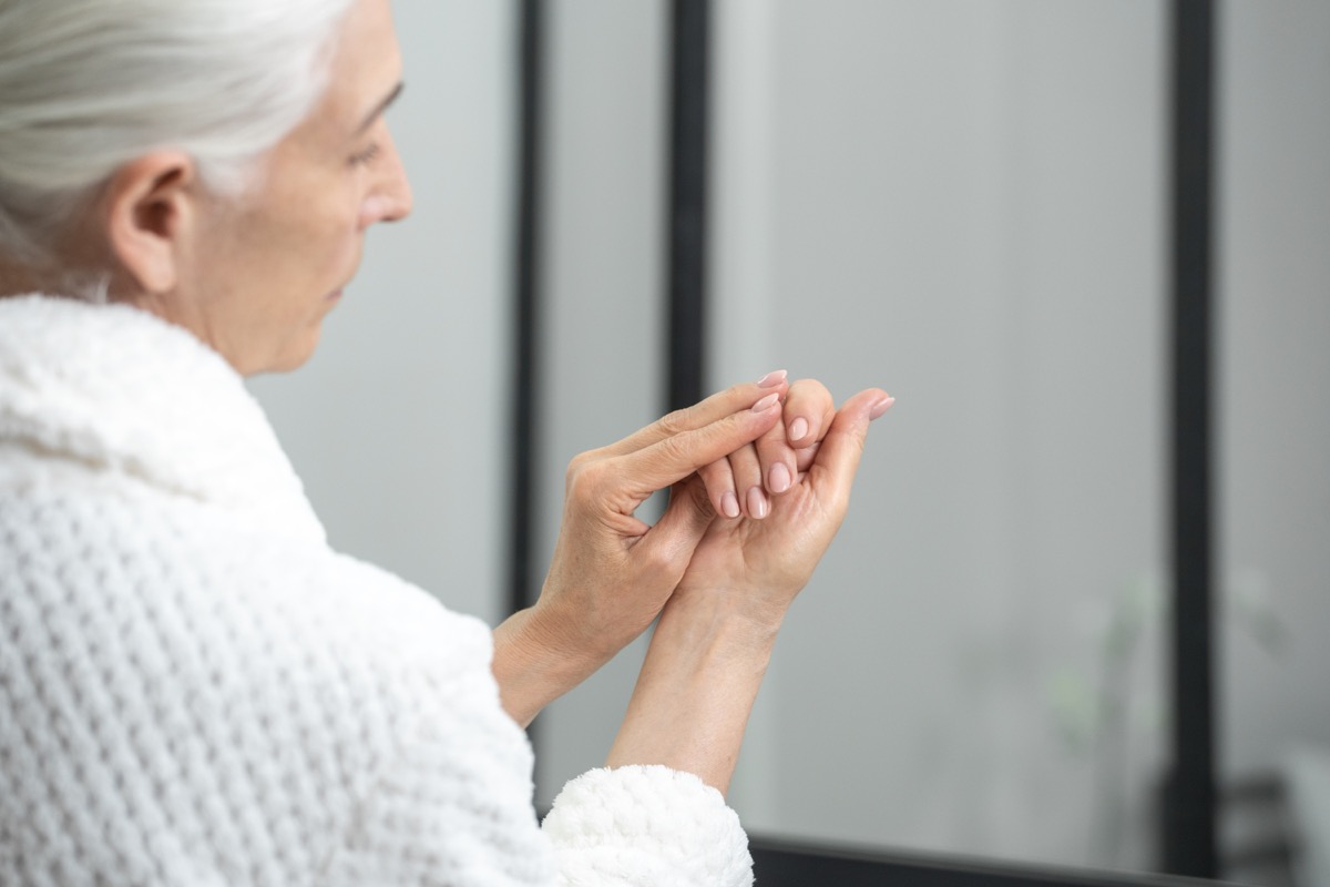 older woman looking at nails