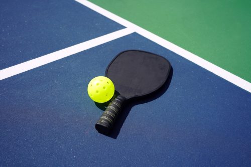 single racket and pickleball ball