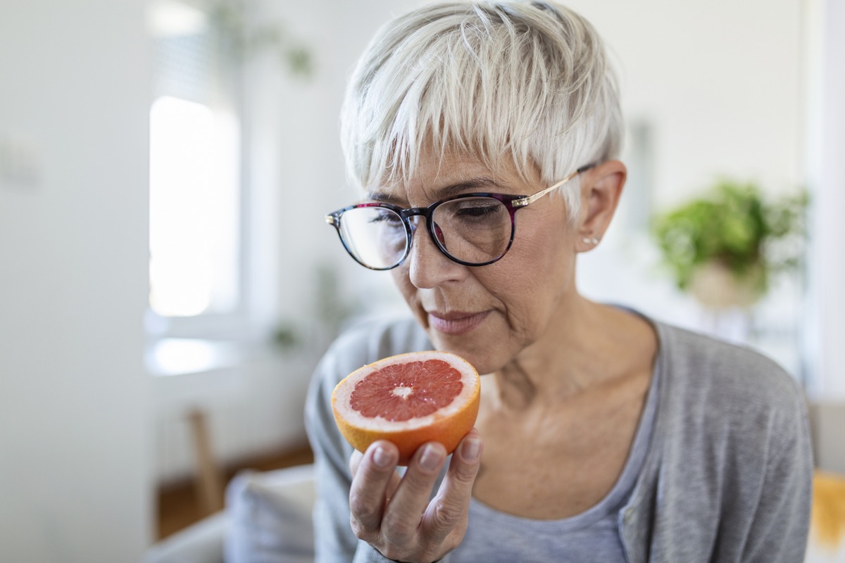 Mature woman smelling a grapefruit