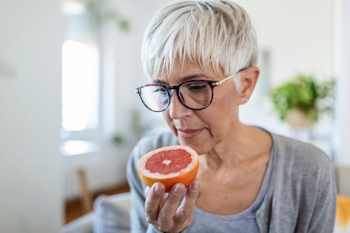 Mature woman smelling a grapefruit