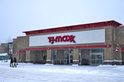 Store front during a winter snow storm with customers. T.J.Maxx is an American department store chain that sells brand name items for less.