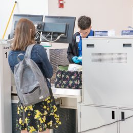 A TSA agent searching a woman's bag at the airport