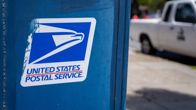United States Postal Service USPS, logo and on mail box on sidewalk
