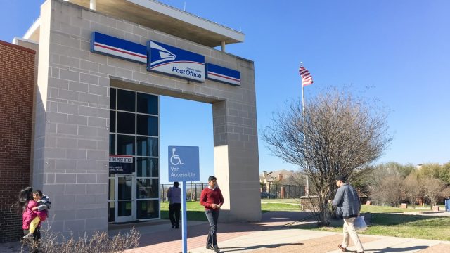 Entrance of USPS store with customers. The United States Postal Service is an independent agency of US federal government for providing postal service national wide