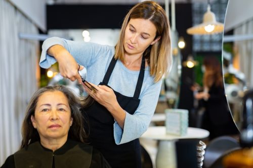 older woman getting her hair cut at a salon