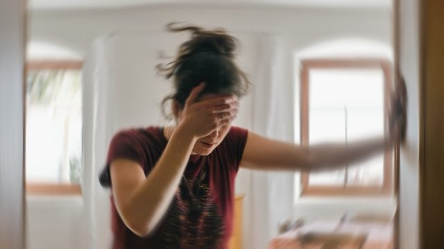 Blurred photo of a woman suffering from headache or stroke