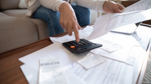 Woman going through bills and receipts at coffee table