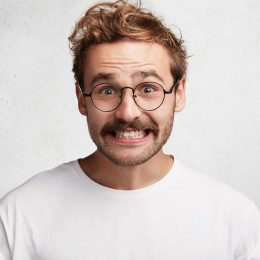 Man in glasses smiling awkwardly