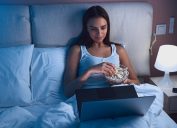 Woman Eating Popcorn in Bed