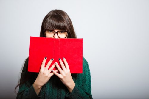 Young Woman Covering Her Face with A Book