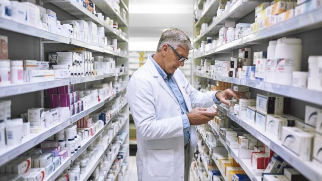 Shot of a focused mature male pharmacist making notes of the medication stock on the shelves in a pharmacy