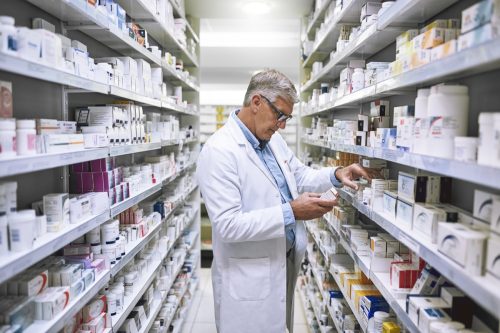 Shot of a focused mature male pharmacist making notes of the medication stock on the shelves in a pharmacy