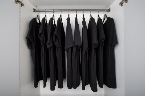 boring wardrobe with same black color shirts on hangers