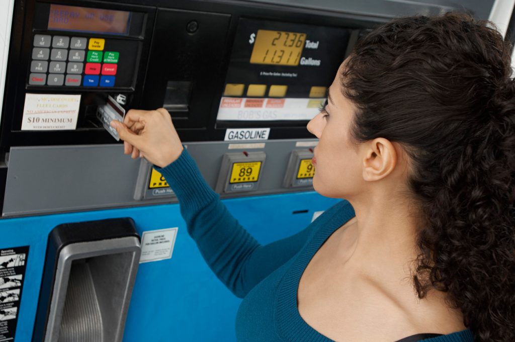 A person paying for gas at the pump using a credit card