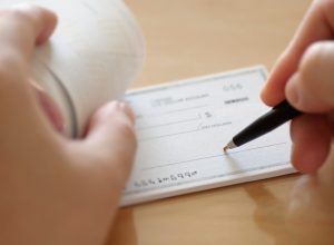 A close-up of someone beginning to write a check