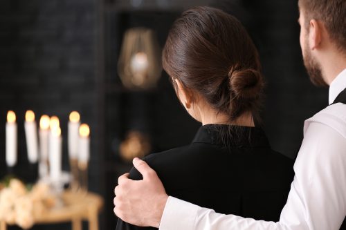 man comforting woman at a funeral