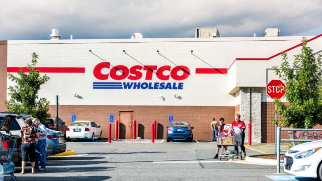 People with shopping carts filled with groceries walking out of Costco store in Virginia in parking car lot