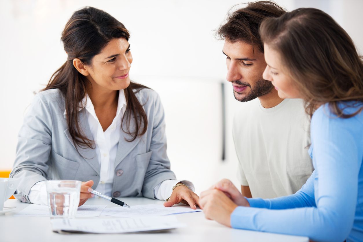 A couple sitting with an accountant and going over their taxes