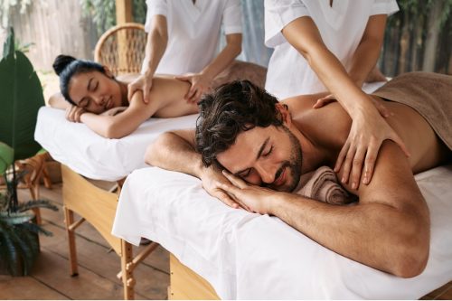 Couple massage at spa resort. Beautiful couple getting a back massage outdoor, romantic weekend