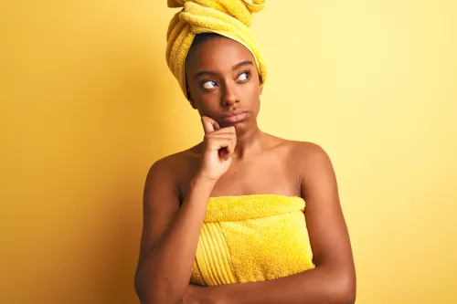 woman in a yellow towel looking contemplative