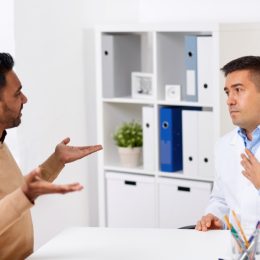 doctor and displeased male patient arguing at clinic