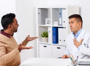 doctor and displeased male patient arguing at clinic