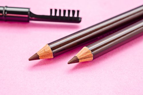Pencils and brush for eyebrows on pink background.