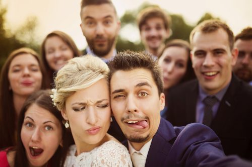 newlyweds making silly faces on their wedding day