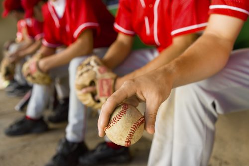 baseball player holding a ball in the dugout