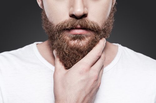 close up of a man stroking his beard