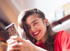 woman smiling while reading flirty texts on her phone