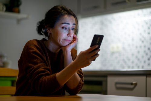 30s woman pouted lips looking at smartphone frustrated by received sms or notification, bad news reading on cell phone feels upset, waiting message from boyfriend, negative response concept.