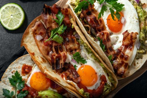 Breakfast tacos with eggs, avocado and bacon