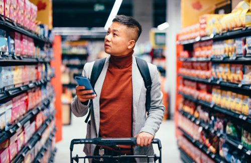 shopper using phone at grocery store