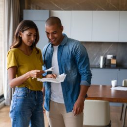 couple at home reading a letter in the mail and looking happy - lifestyle concepts