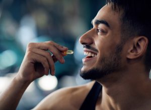 Portrait Of Happy Sportive Arab Man Taking Supplement Capsule,