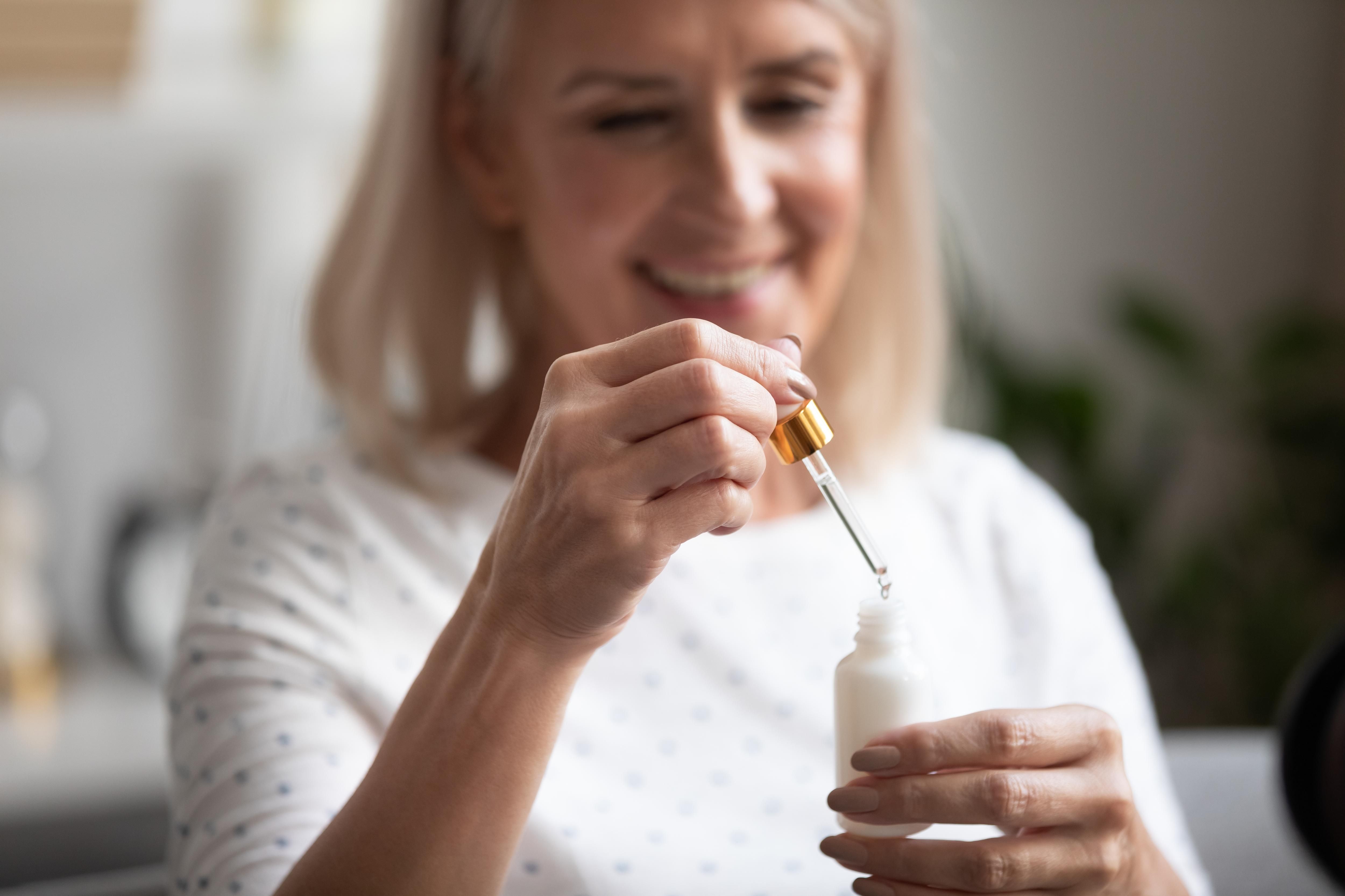 Close,Up,Focus,On,Hands,Of,Mature,Female,Holding,Bottle