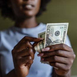 A closeup of a person counting and using $20 bills