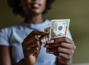 A closeup of a person counting and using $20 bills
