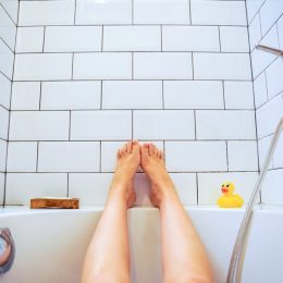 Female feet in bathtub with rubber duckie