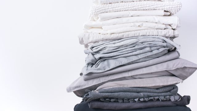A stack of grey and white folded sheets.