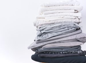 A stack of grey and white folded sheets.